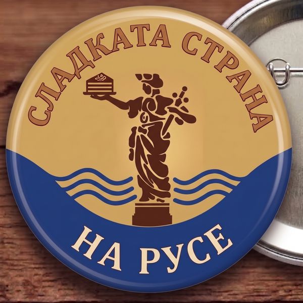 Значка „Сладката страна на Русе“: „Сладката страна на Русе“: Статуята на Свободата е хвърлила меча и гордо държи парче торта Гараш.